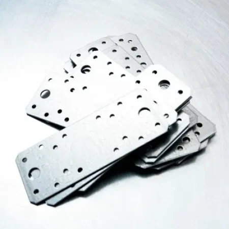 Placas metálicas perforadas listas tras aplicar tipos de maquinado industrial por troquelado de alta precisión.